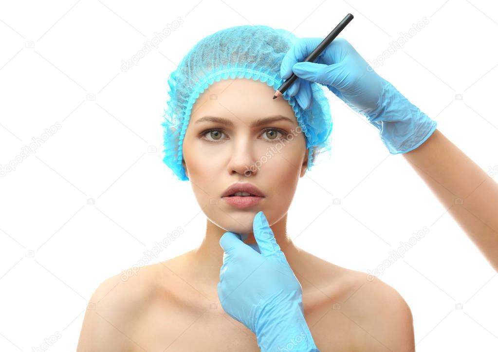 Plastic surgeon drawing line on face 