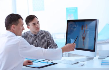 Medical concept. Doctor showing results of urology diagnostic on computer monitor clipart