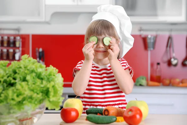 Menina pequena brincando com legumes — Fotografia de Stock