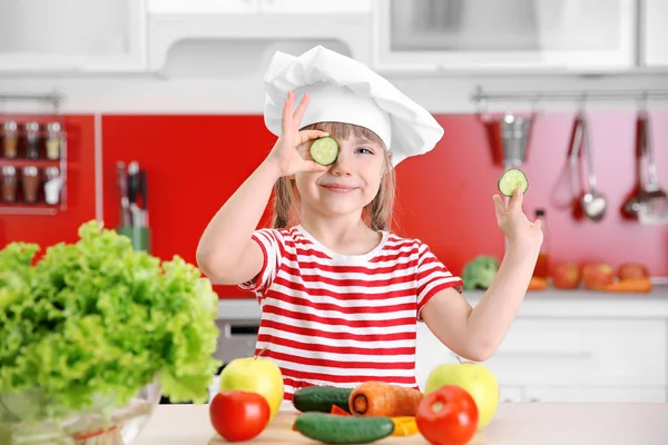Menina pequena brincando com legumes — Fotografia de Stock
