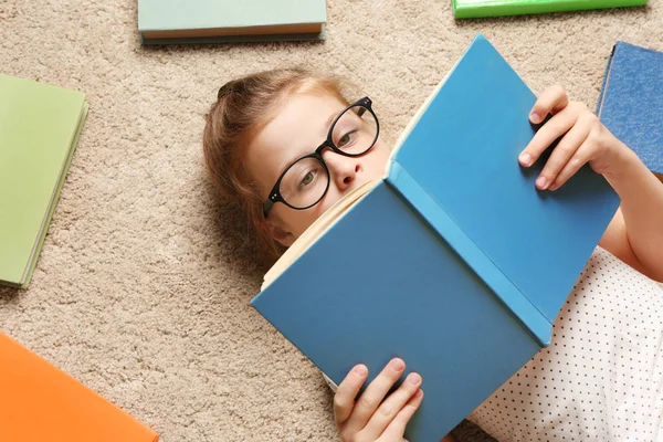 Χαριτωμένο κορίτσι με τα βιβλία που βρίσκονται στον όροφο — Φωτογραφία Αρχείου
