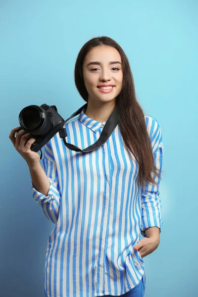 Hermoso joven fotógrafo sobre fondo de color — Foto de Stock