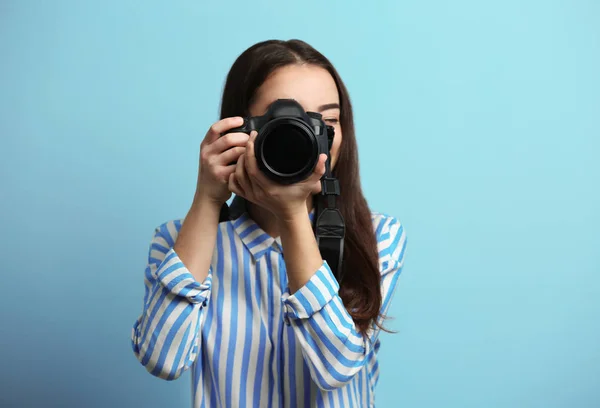 Beautiful young photographer on color background — Stock Photo, Image