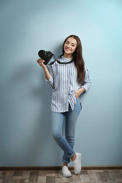 Mooie jonge fotograaf in de buurt van kleur muur — Stockfoto