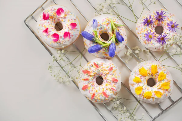 Delicious donuts and flowers — Stock Photo, Image
