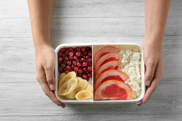 Mãos segurando caixa com café da manhã saudável — Fotografia de Stock