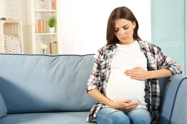 Молода вагітна жінка погано почувається вдома — стокове фото