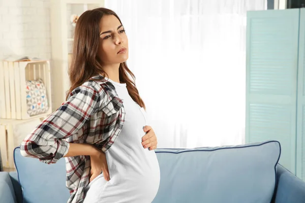 Mladá těhotná žena se cítí špatně doma — Stock fotografie
