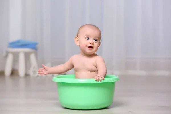 Симпатичный ребенок в пластиковой раковине — стоковое фото