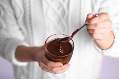 Fincan çikolatalı mousse ile tutan kadın
