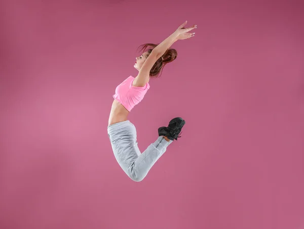 Танцор хип-хопа танцует на розовом фоне — стоковое фото