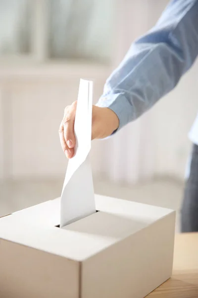 Рука вставляє конверт у поле для голосування — стокове фото