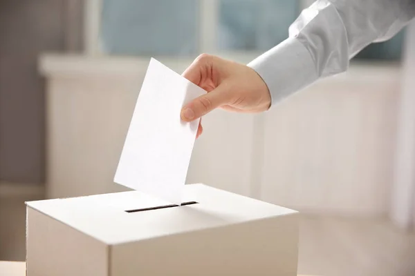 Hand legt Umschlag in Wahlurne — Stockfoto
