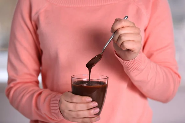 Frau hält Tasse mit Schokoladenmousse — Stockfoto