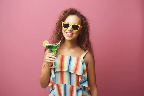 Молодая красивая женщина с вкусным коктейлем на цветном фоне — стоковое фото