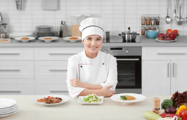 Jonge vrouw chef met drie bereide gerechten op borden — Stockfoto