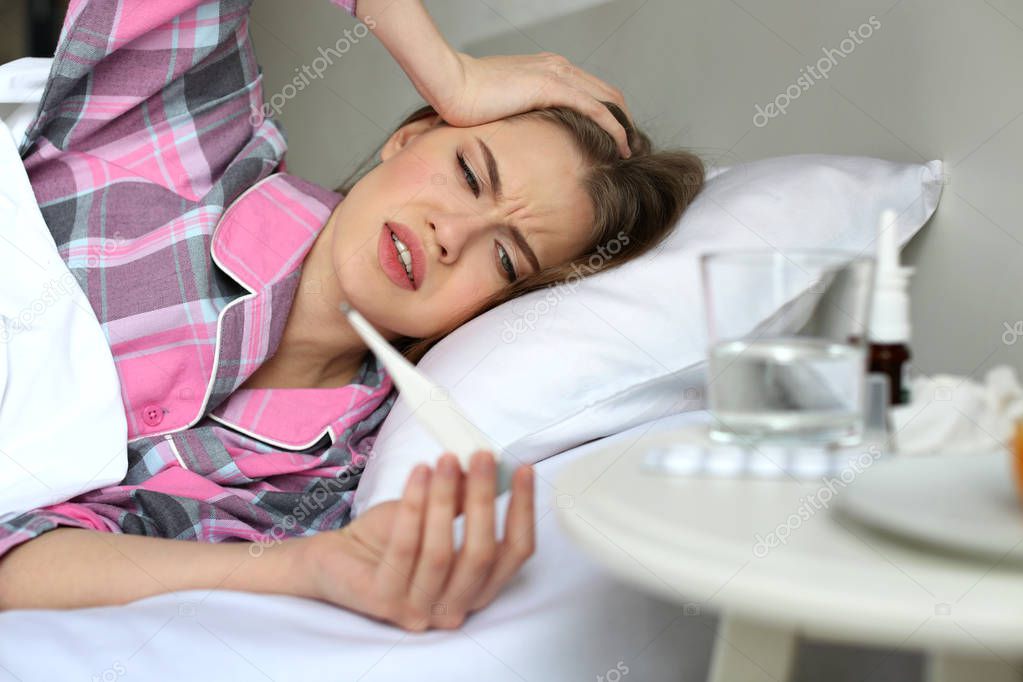 ill woman with electronic thermometer