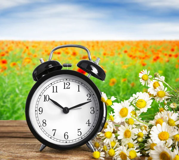 Alarm clock against nature landscape — Stock Photo, Image