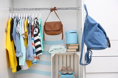 bir raf üzerinde asılı elbiseleri