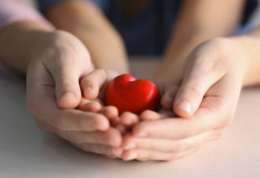 Kalp işareti tutan çocuk