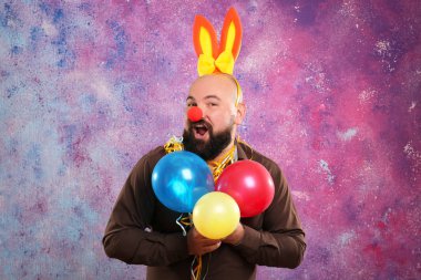 Komik şişman adam renk arka plan üzerinde parti dekor, balonlar ve tavşan kulaklı