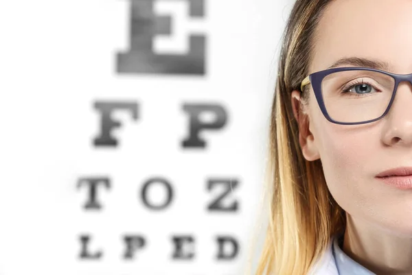 Jonge vrouw op gezichtsvermogen test-chart — Stockfoto