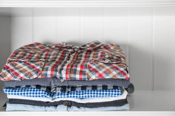 Stack av kläder på hyllor — Stockfoto