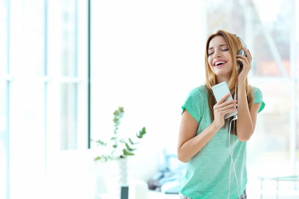 Vacker ung kvinna som lyssnar på musik — Stockfoto