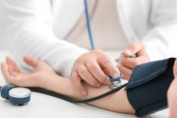 Doctor measuring blood pressure — Stock Photo, Image