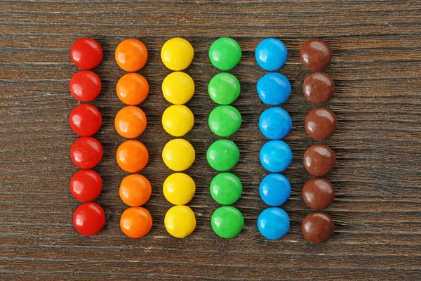 Bonbons colorés sur table en bois — Photo