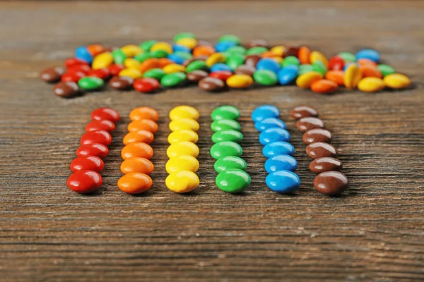 Doces coloridos na mesa de madeira — Fotografia de Stock