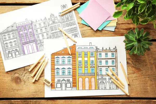 Dibujos para colorear y lápices en mesa de madera — Foto de Stock