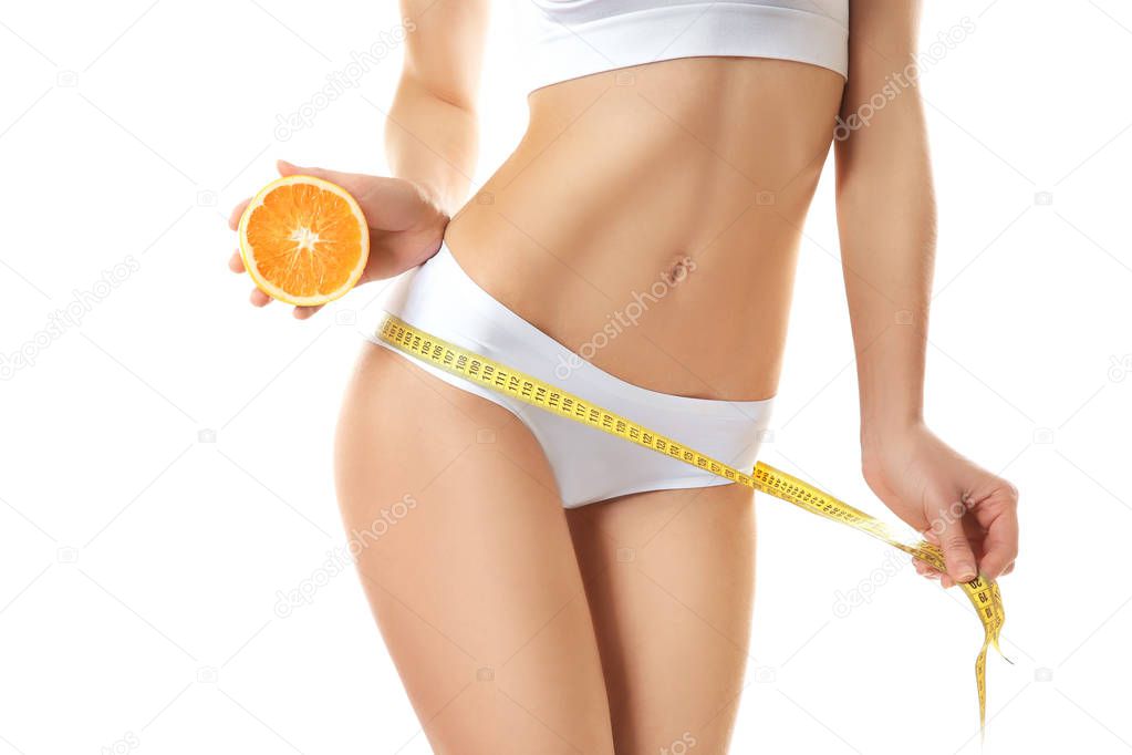 Woman with measuring tape and sliced orange