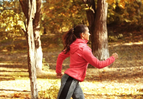 Giovane donna che corre nel parco — Foto Stock