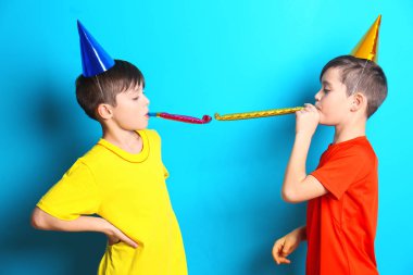 Parti şapkaları mavi zemin üzerine çocuklarla şirin doğum günü