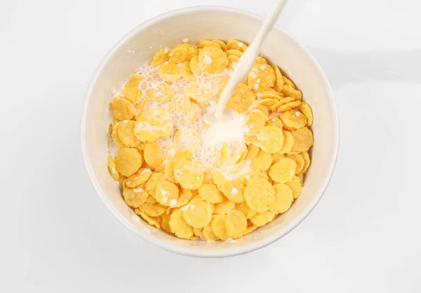 Verter leche en un tazón con cereales de maíz — Foto de Stock