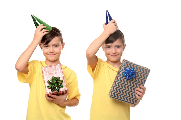逗人喜爱的双胞胎男孩与生日帽子和礼物在白色背景 — 图库照片