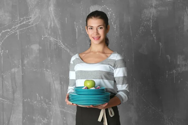 Mujer sosteniendo platos con manzana — Foto de Stock