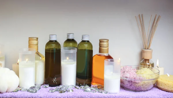 Bottles of essential oil and candles — Stock Photo, Image