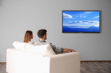 Evde televizyon izlerken aile. Boş zaman ve eğlence kavramı.