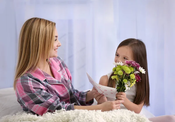 Menina bonito cumprimentando sua mãe em casa. Conceito de dia da mãe — Fotografia de Stock