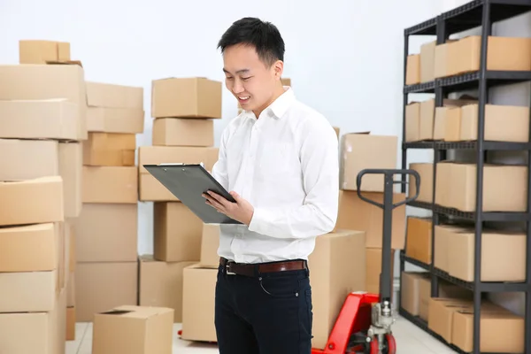 Hombre con el portapapeles de verificación de pedidos en almacén de la empresa logística —  Fotos de Stock