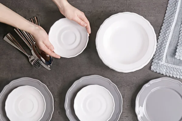Женские руки с блюдцем и посудой — стоковое фото