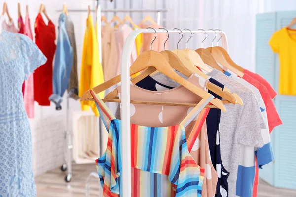 Fashionable clothes hanging on rack — Stock Photo, Image