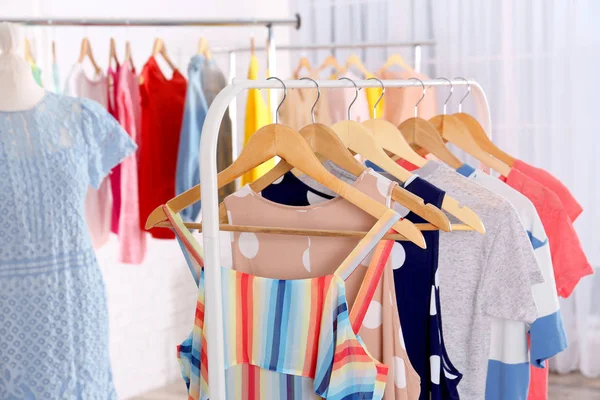 Fashionable clothes hanging on rack — Stock Photo, Image