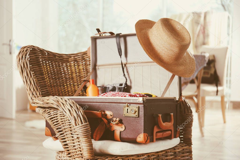 Packed suitcase on wicker chair