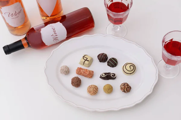 Delicious chocolate candies and red wine — Stock Photo, Image