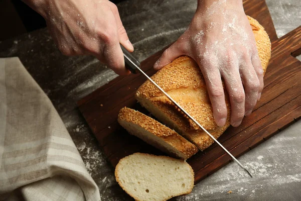 Manos masculinas cortar pan — Foto de Stock