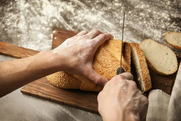 Male hands cutting  bread — Stock Photo, Image