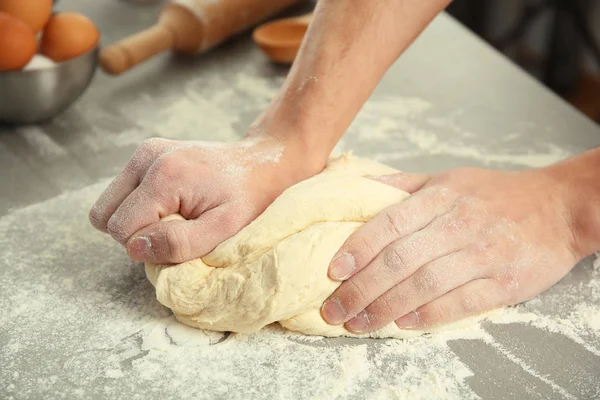 Mains masculines pétrissant la pâte — Photo